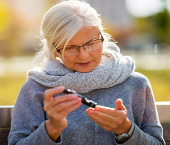an old woman checking her blood sugar level